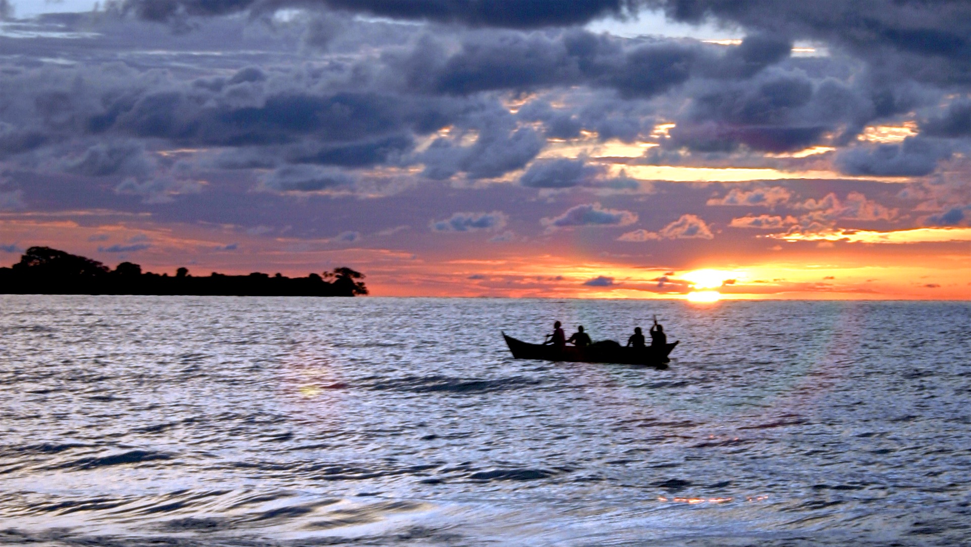 Fishermen rowing out onto Lake Victoria at dusk near Kisumu
